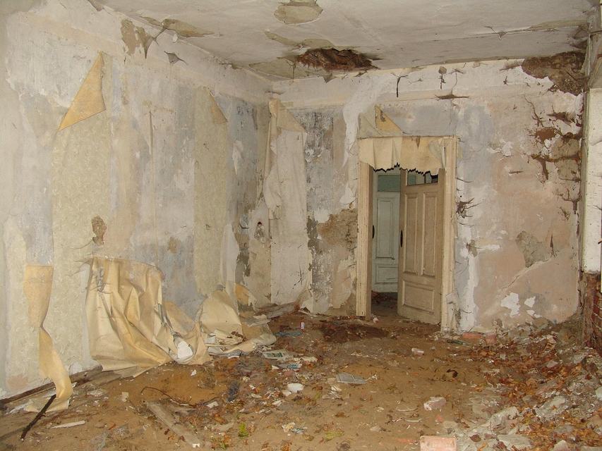 Zimmer in einem alten Haus während der Renovierung, Tapeten lösen sich von der Wand